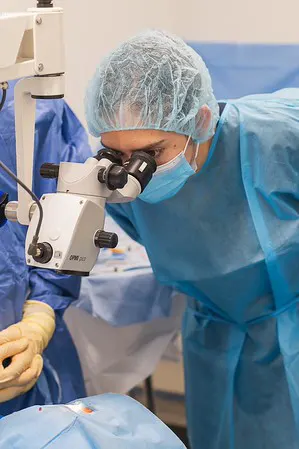 Profissional de saúde em procedimento clínico, com atenção e excelência técnica