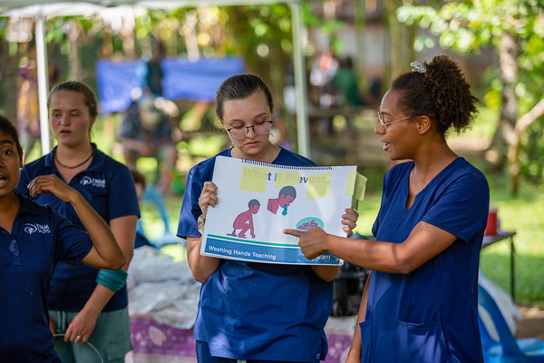 Educadoras em saúde ensinando cuidados básicos em campo